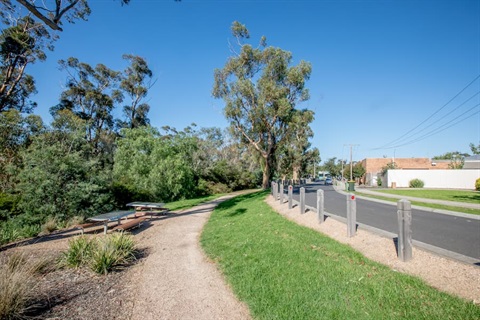 Landscaped path lined with trees and grass along a road. (Westmeadows)